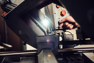 Worker operating band saw cutting machine