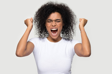 Happy cheerful excited african woman pose over grey background