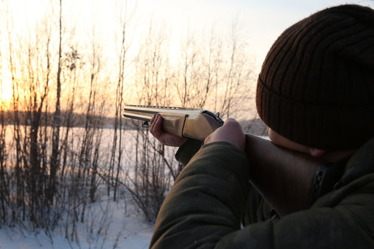 Hunter takes aim at the prey. The man holding the hunting gun ready. hunter shoots a rifle at the fowl.  P