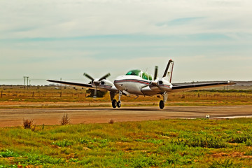 Fototapeta na wymiar White twin engine aircraft taking off