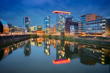 Düsseldorf, Deutschland. Stadtbild von Düsseldorf, Deutschland mit dem Medienhafen und der Spiegelung der Stadt im Rhein, während der blauen Stunde der Dämmerung. © rudi1976