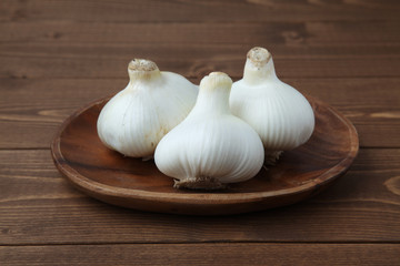 木のテーブルにのせた 生のニンニク ガーリック 木の皿