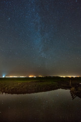 Reflection of the Milky Way Galaxy in a pond of water, in the Frisian countryside