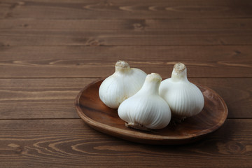 木のテーブルにのせた 生のニンニク ガーリック 木の皿