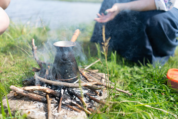 coffee is brewed in turkish on a fire in nature