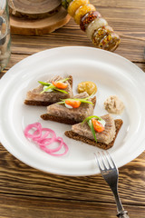 Holodets Homemade jellied meat with garlic and spices garnished with onion on rye bread on wooden table