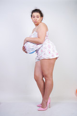 middle-aged girl really wants to get pregnant. woman standing in pajamas with an air balloon under...