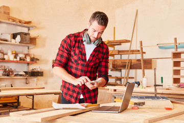 Handwerker schreibt SMS auf dem Smartphone