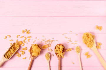 A set of different types of Italian pasta on a colored background top view, place for text.