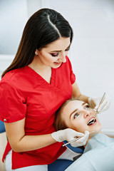 Woman dentist working at her patients teeth