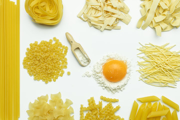 Collection of italian pasta, flour and chicken egg isolated top view on white background.