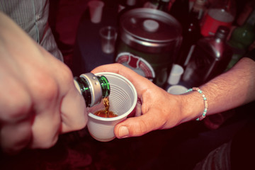 hand pours alcohol in the glass, alcoholism concept