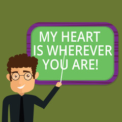 Writing note showing My Heart Is Wherever You Are. Business photo showcasing Expressing roanalysistic feelings and emotions Man Standing Holding Stick Pointing to Wall Mounted Blank Color Board