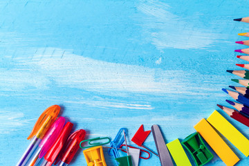colorful pencils, markers and pens composition mock-up Back to school concept with stationery office supplies on a blue wooden background with copy space close-up top view