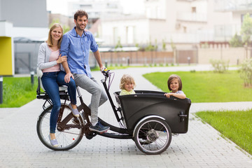 Fototapeta na wymiar Young family having a ride with cargo bike