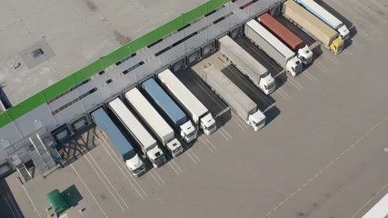 Aerial shot of truck drives up at warehouse for loading or unloading. Logistics, distribution center.
