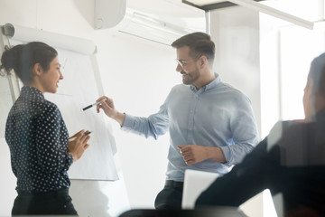 Diverse speakers make flip chart presentation in conference room