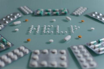 set of loose pills and complete tablets on green glass table