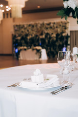 Table setting for a wedding ceremony at swimming pool. round table with white tablecloth