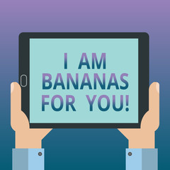 Handwriting text writing I Am Bananas For You. Concept meaning To be crazy for someone in loved happy emotion Hu analysis Hand Holding Blank Screen Tablet Smartphone Display Unit photo