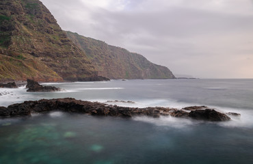 Fototapeta na wymiar Mesa del Mar volcanic rocks coastline, long exposure photography, Atlantic ocean with sunset light, Tacoronte, Tenerife, Canary islands, Spain