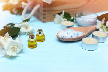 Fototapeta na wymiar Aromatic oils, sea salt, candles and jasmine flowers. Spa ingredients for massage and relaxation.