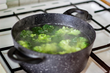 Broccoli boiling in the pot in the house.