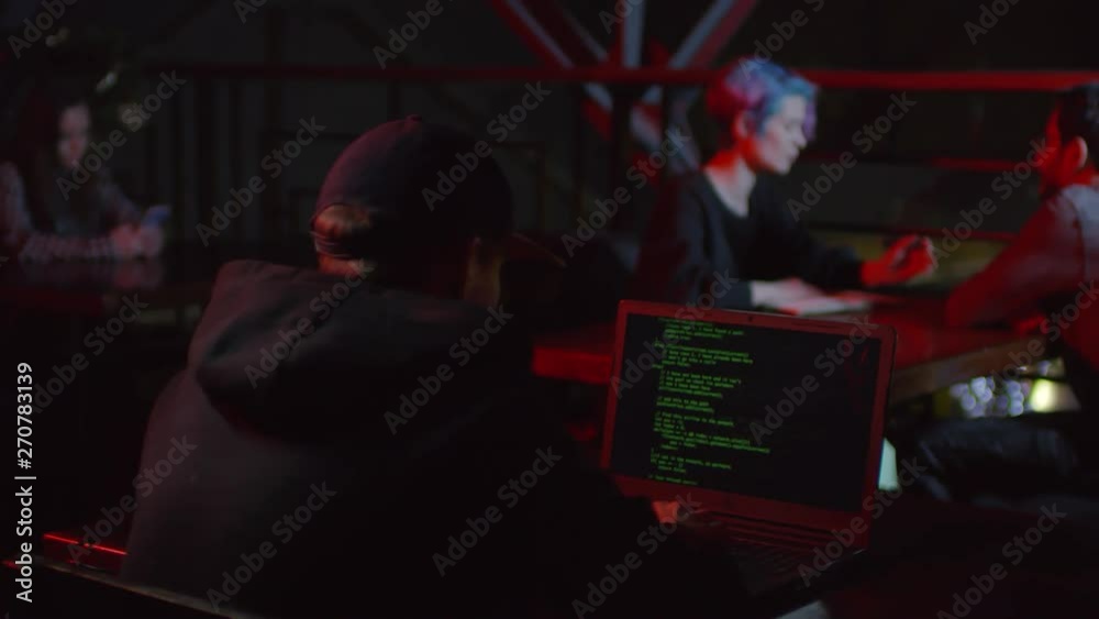 Wall mural rare view of hacker sitting in café at laptop and developing new software