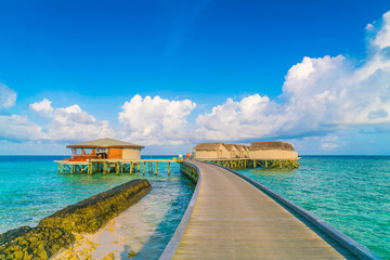 Beautiful water villas in tropical Maldives island at the sunrise time .