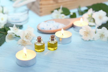 Fototapeta na wymiar Aromatic oils, sea salt, candles and jasmine flowers. Spa ingredients for massage and relaxation.