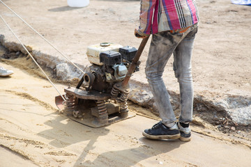 Young builder on Asphalting paver machine during Road street repairing works