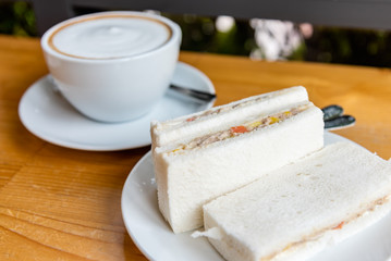 Refreshing and delicious breakfast with coffee latte and tuna sandwich.