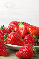Fresh strawberries in plate on wood