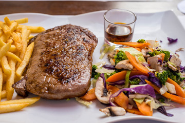 Grilled steak, French fries and vegetables