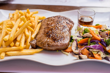 Grilled steak, French fries and vegetables