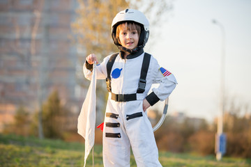 Adorable little boy, dressed as astronaut, playing in park