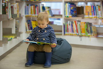 Smart children, boy brothers, educating themselves in a library