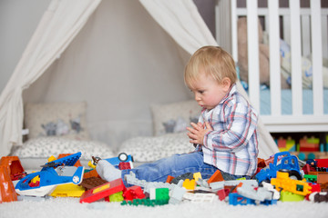 Child toddler playing with construction toys at home