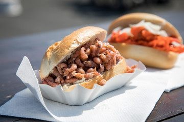 Fischbrötchen mit Nordseekrabben und Alaska Seelachs draußen auf Fischmarkt Holztisch als schneller regionaler Imbiss