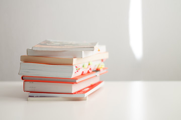 books in a pile on top of each other lie on a white background close-up