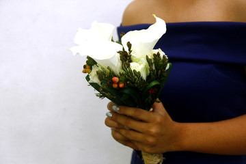 Hand of a bridesmaid holding a bouquet of flowers