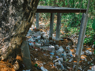 Garbage under the tree.Spilled garbage city. Empty used dirty plastic bottles. Dirty. Environmental pollution. Ecological problem.