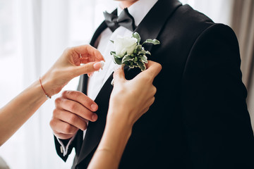 stylish groomsmen helping happy groom getting ready in the morning for wedding ceremony. luxury man...