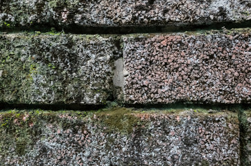 rough stone brick wall with lichen and moss