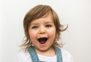 Happy blonde caucasian baby child laughing and smiling on neutral background close portrait 