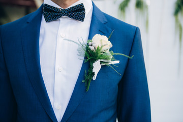 stylish groomsmen helping happy groom getting ready in the morning for wedding ceremony. luxury man...