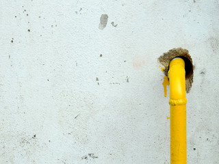 aged street white wall with yellow pipe