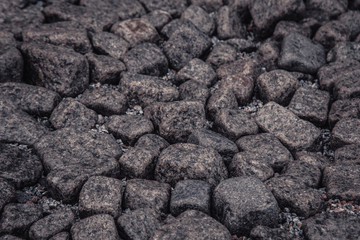 gray stone pavement unevenly laid out on the ground top view. texture, background, wallpaper