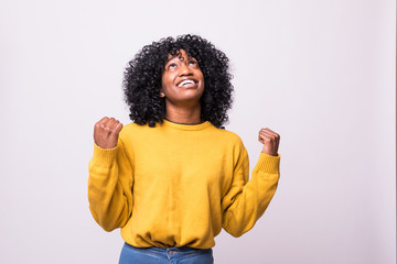 Overjoyed young african american woman screaming with joy celebrating victory win success isolated on grey white studio background. Happy excited black girl rejoicing triumph feeling winner