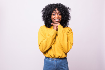 Portrait of thoughtful young african woman with curly black hair looking up with her hand on the...